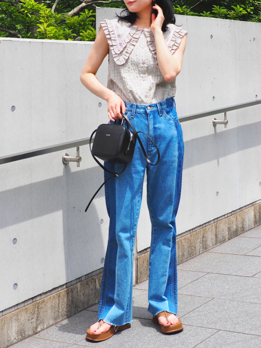 ブルー系のデニムパンツ、パープル系のシャツ/ブラウス、ブラウン系のサンダルを着用したレディースの春コーディネートの5枚目の写真