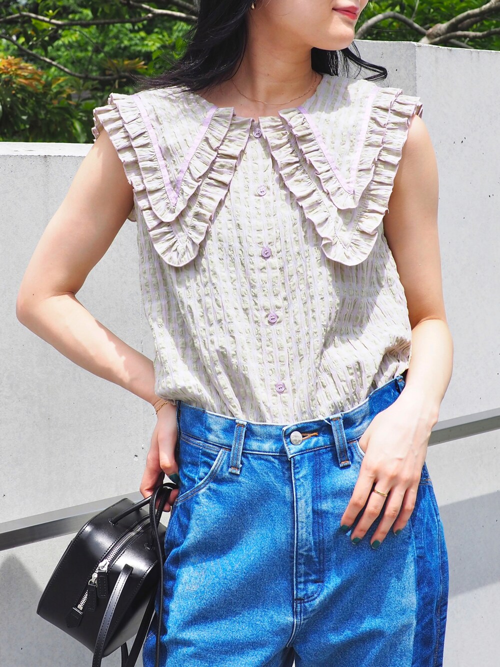 ブルー系のデニムパンツ、パープル系のシャツ/ブラウス、ブラウン系のサンダルを着用したレディースの春コーディネートの2枚目の写真