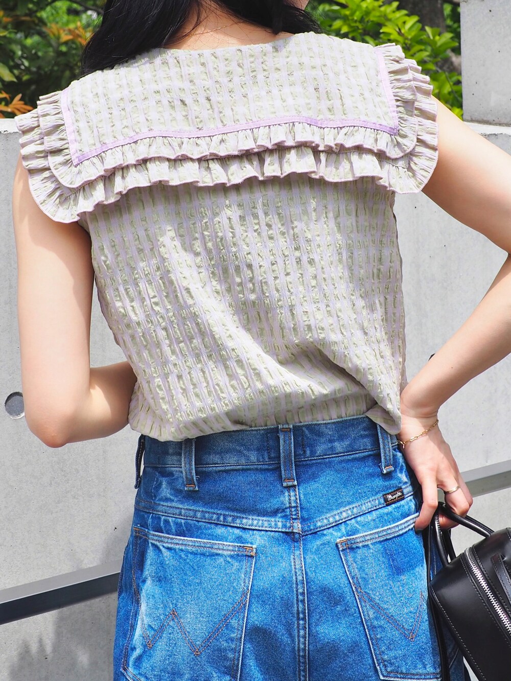 ブルー系のデニムパンツ、パープル系のシャツ/ブラウス、ブラウン系のサンダルを着用したレディースの春コーディネートの3枚目の写真