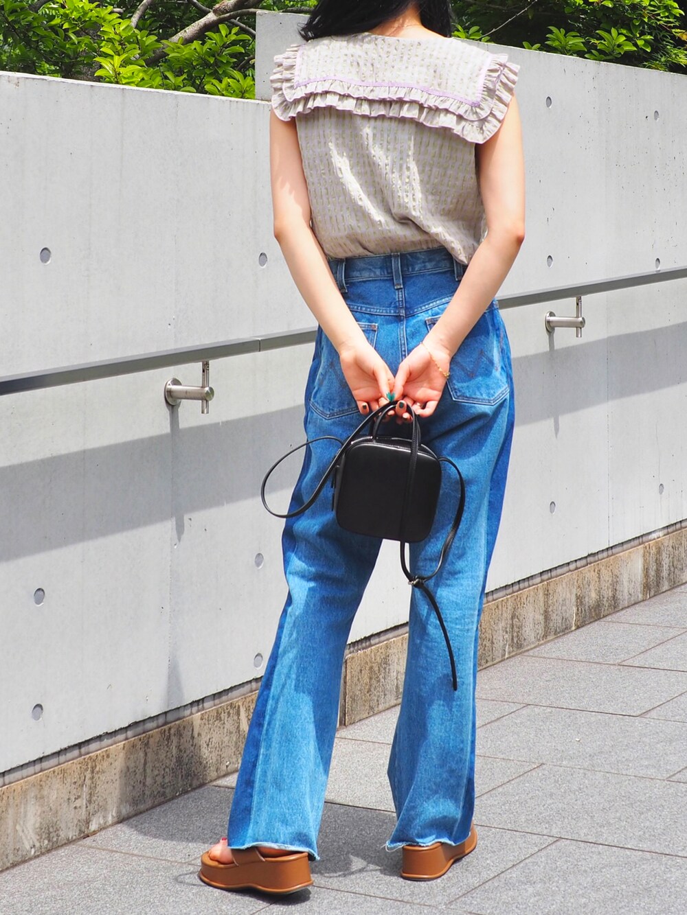 ブルー系のデニムパンツ、パープル系のシャツ/ブラウス、ブラウン系のサンダルを着用したレディースの春コーディネートの4枚目の写真