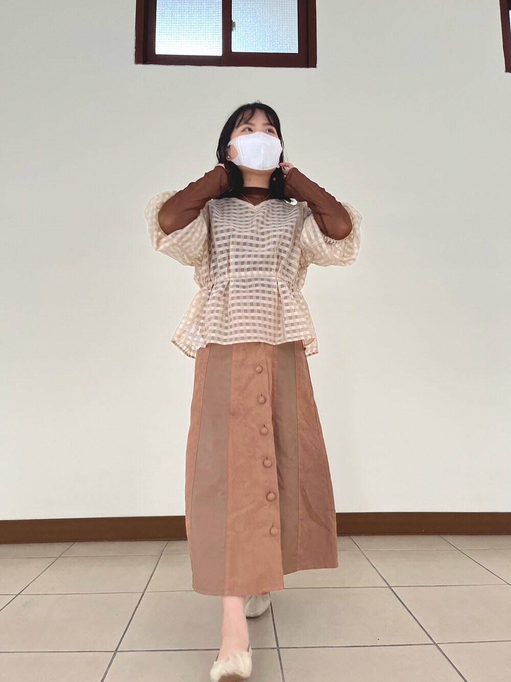 ベージュ系のトップス、ブラウン系のトップスを着用したレディースの春コーディネートの2枚目の写真