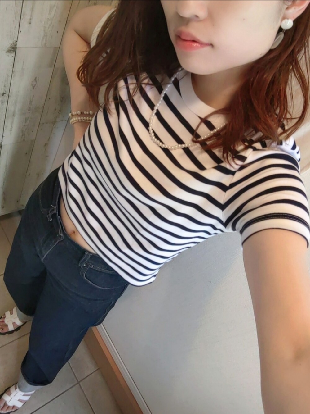 ホワイト系のTシャツ/カットソー、ブルー系のデニムパンツ、ホワイト系のサンダルを着用したレディースの夏コーディネートの2枚目の写真