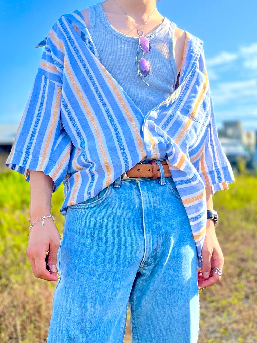 ブルー系のシャツ/ブラウス、ブルー系のデニムパンツ、オレンジ系のブーツを着用したメンズの夏コーディネートの3枚目の写真