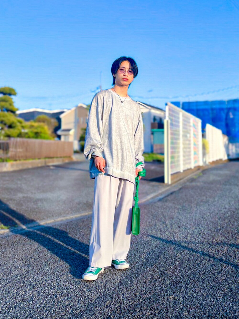 グリーン系のスニーカー、グリーン系のショルダーバッグ、グレー系のTシャツ/カットソーを着用したメンズの春コーディネートの2枚目の写真