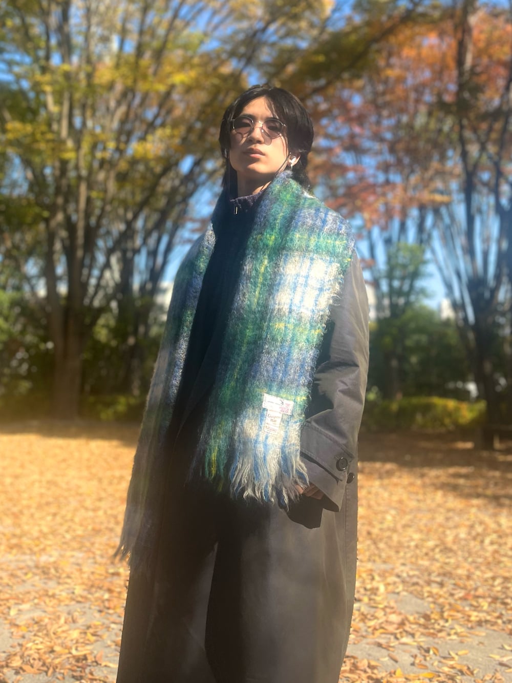 ブラック系のトレンチコート、ブラック系のスラックス、ブラック系のスニーカーを着用したメンズの冬コーディネートの3枚目の写真