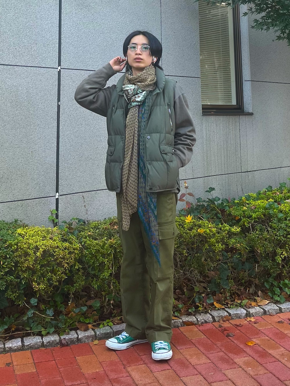 グリーン系のスニーカー、グリーン系のダウンベスト、グリーン系のカーゴパンツを着用したメンズの冬コーディネートの3枚目の写真