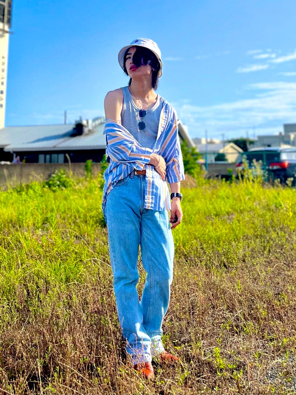 ブルー系のシャツ/ブラウス、ブルー系のデニムパンツ、オレンジ系のブーツを着用したメンズの夏コーディネートの2枚目の写真