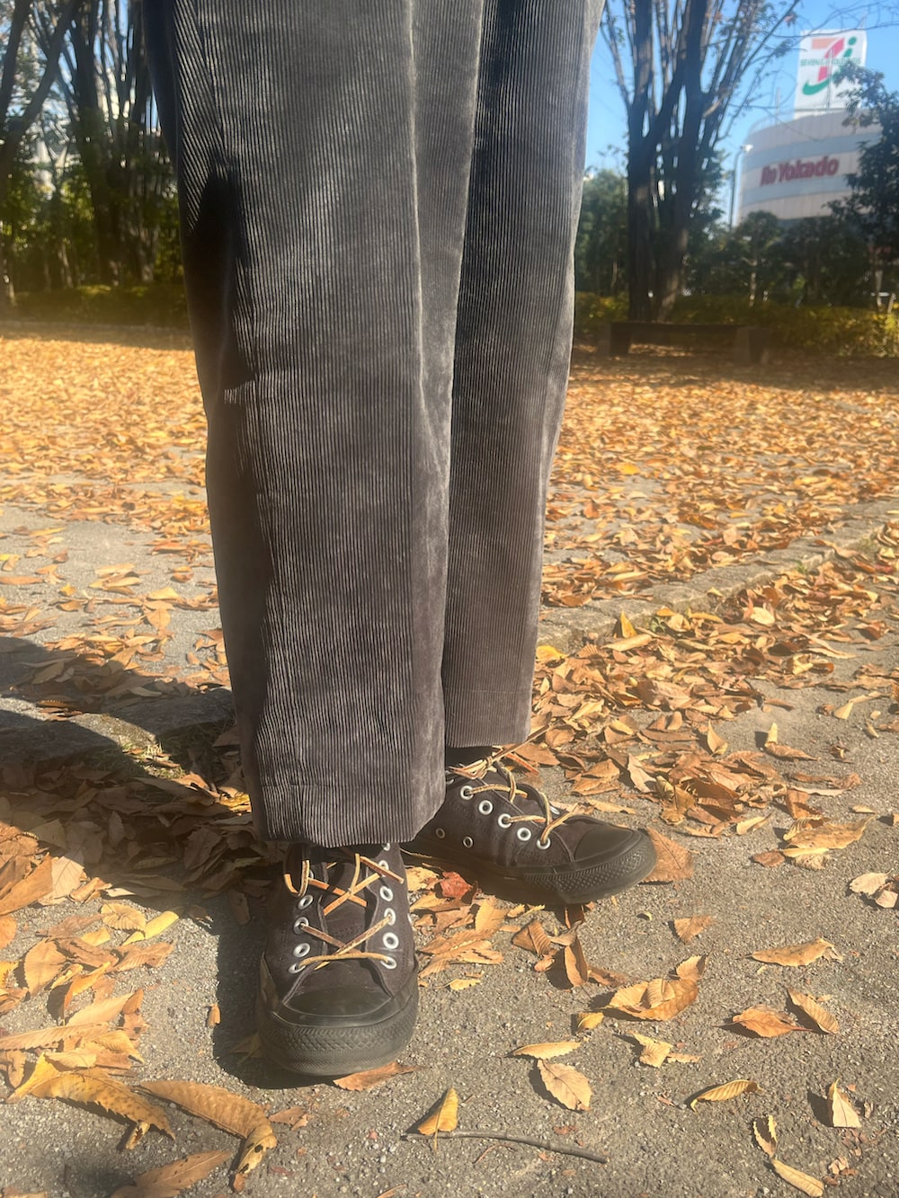 ブラック系のトレンチコート、ブラック系のスラックス、ブラック系のスニーカーを着用したメンズの冬コーディネートの5枚目の写真