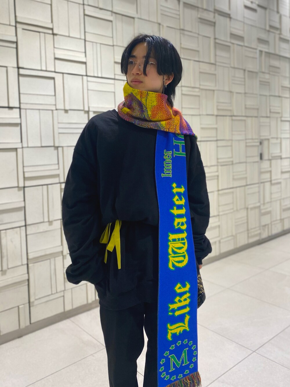 ブラック系のスウェット、ゴールド系のクラッチバッグ、ブラック系のスラックスを着用したメンズの冬コーディネートの3枚目の写真