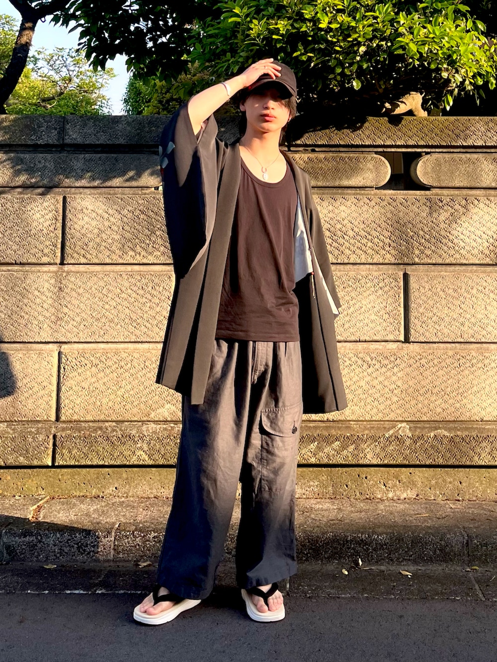 ブラック系のその他アウター、グレー系のカーゴパンツ、ホワイト系のサンダルを着用したメンズの夏コーディネートの3枚目の写真