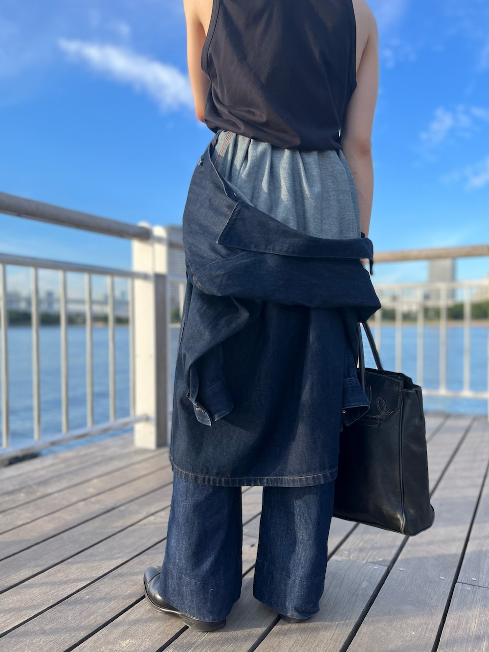 ブルー系のステンカラーコート、ブラック系のタンクトップ、ブラック系のトートバッグを着用したメンズの夏コーディネートの3枚目の写真