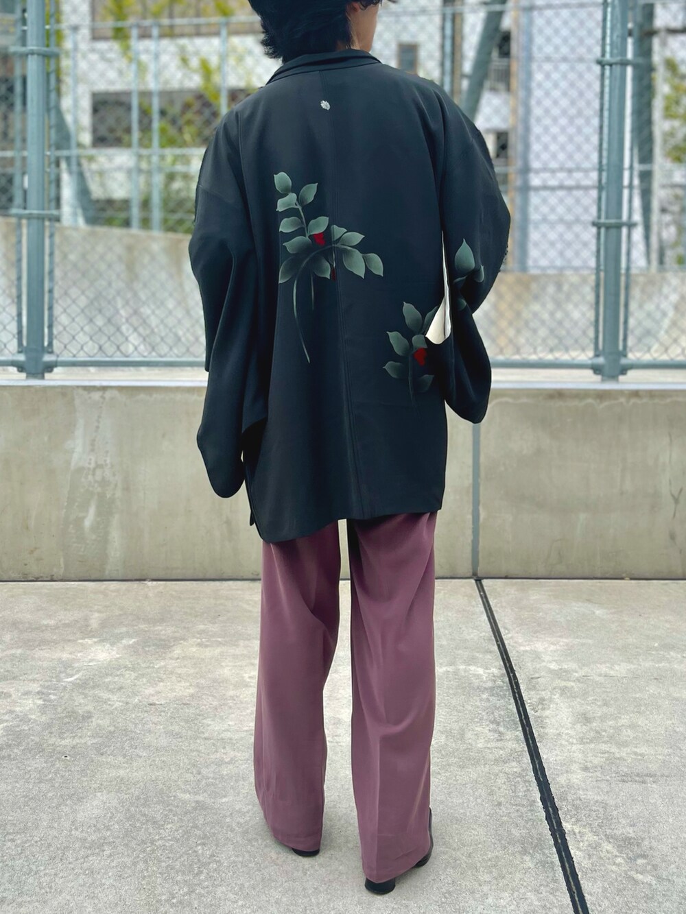 パープル系のスラックス、ブラック系のその他アウター、レッド系のTシャツ/カットソーを着用したメンズの秋コーディネートの4枚目の写真