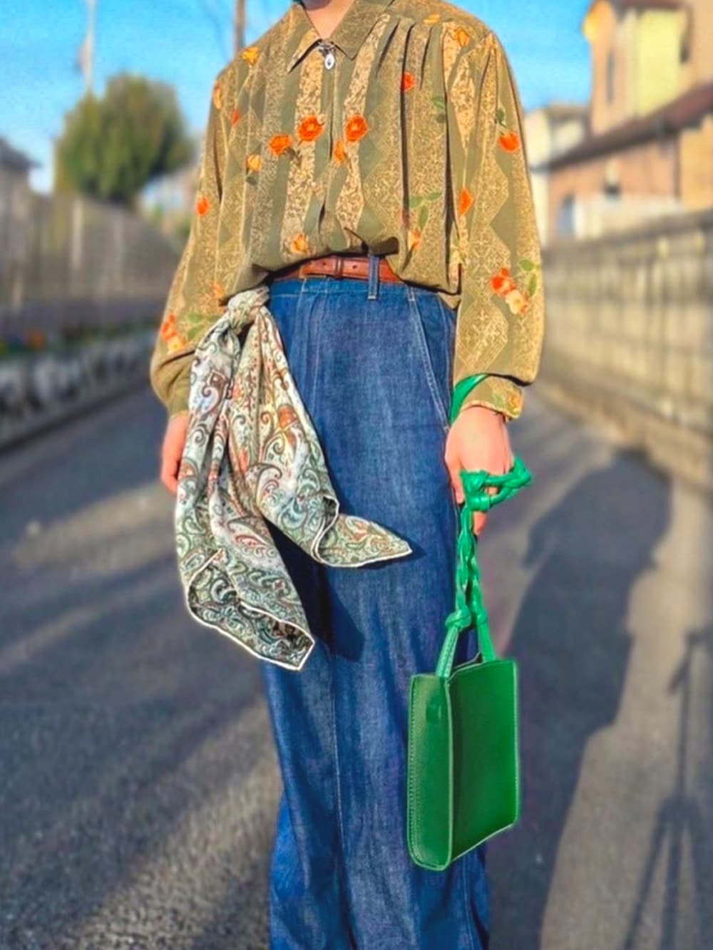 ブルー系のスニーカー、グリーン系のショルダーバッグ、ブルー系のデニムパンツを着用したメンズの春コーディネートの3枚目の写真