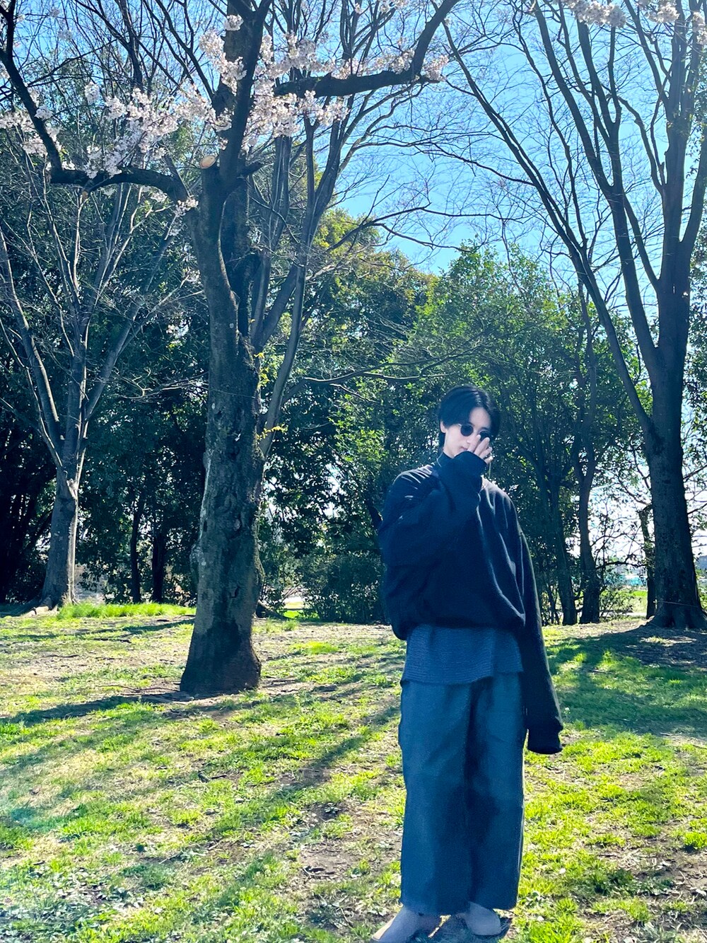 グレー系のカーゴパンツ、ベージュ系のスリッポン、ブラック系のスウェットを着用したメンズの春コーディネートの2枚目の写真