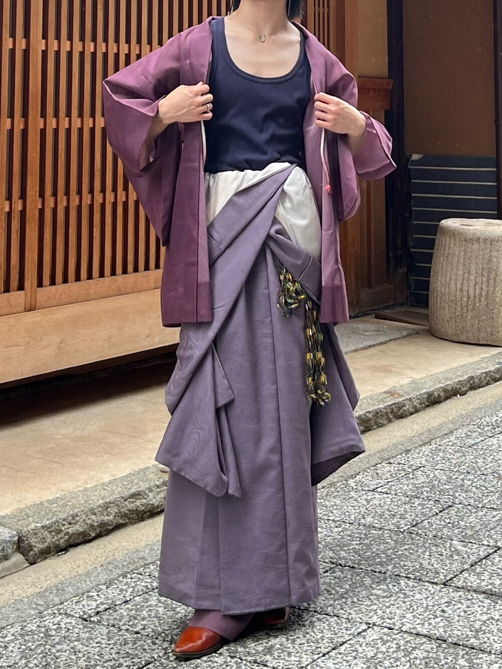 オレンジ系のブーツ、ブルー系のタンクトップ、ゴールド系のメガネを着用したメンズの秋コーディネートの4枚目の写真