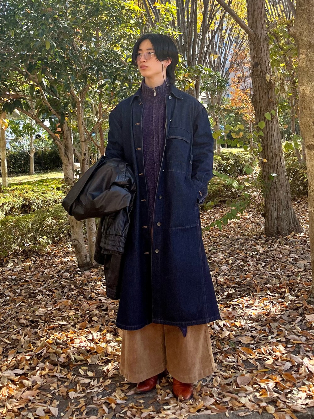 ブラウン系のその他パンツ、オレンジ系のブーツ、ブルー系のステンカラーコートを着用したメンズの秋コーディネートの3枚目の写真