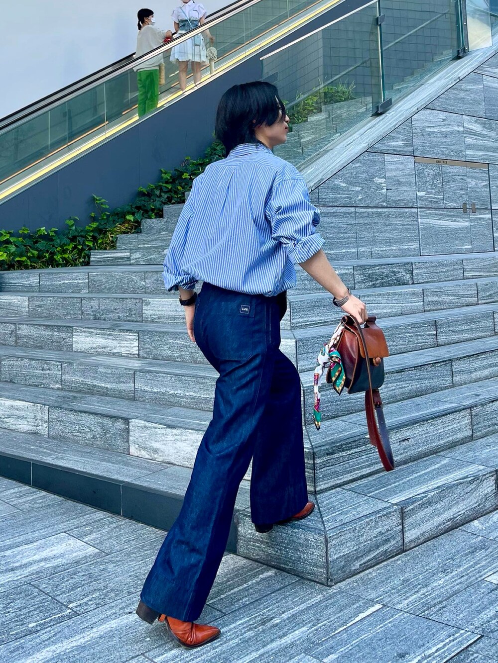 オレンジ系のブーツ、ブルー系のシャツ/ブラウス、ブルー系のデニムパンツを着用したメンズの夏コーディネートの4枚目の写真