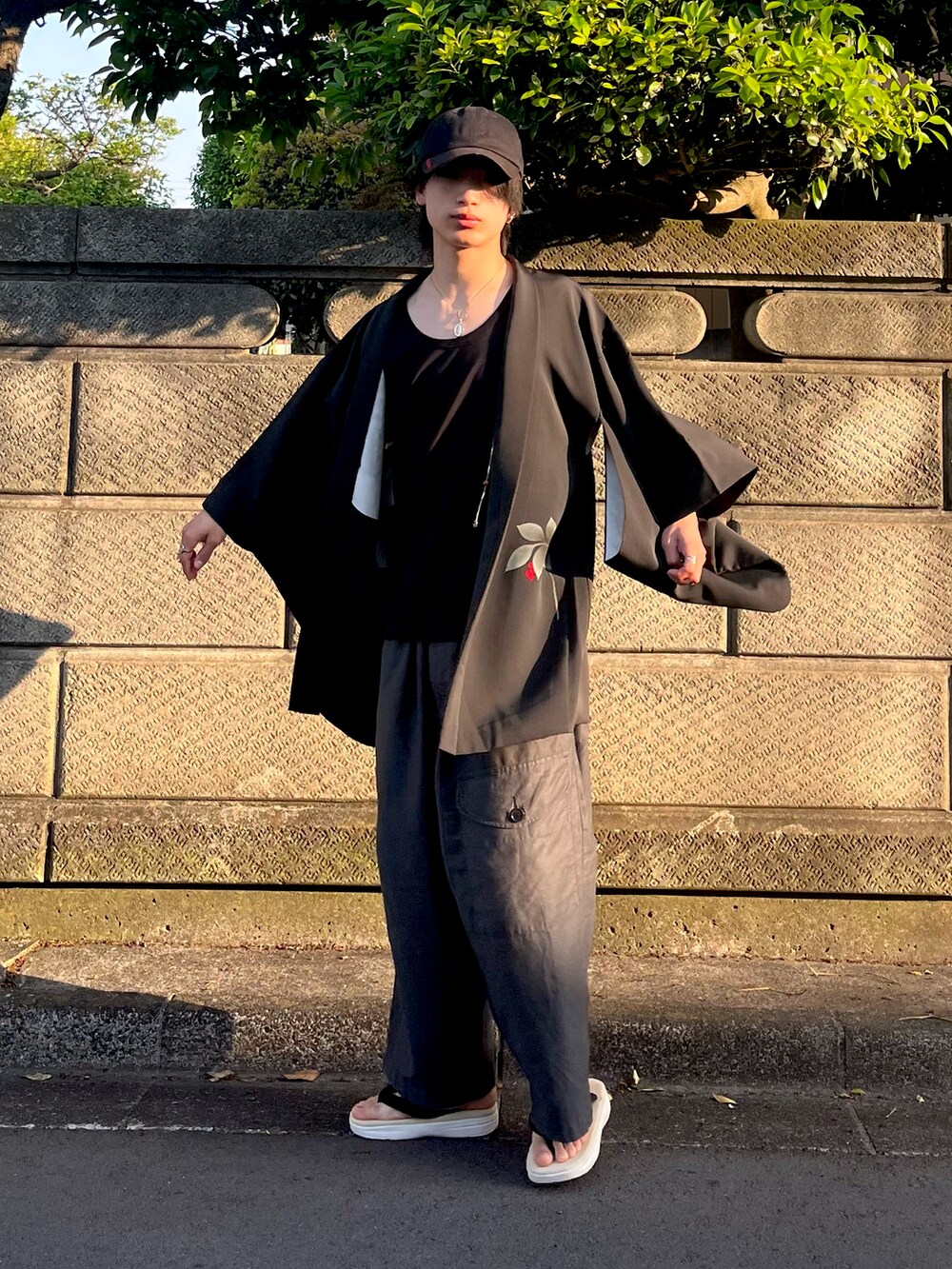 ブラック系のその他アウター、グレー系のカーゴパンツ、ホワイト系のサンダルを着用したメンズの夏コーディネートの2枚目の写真