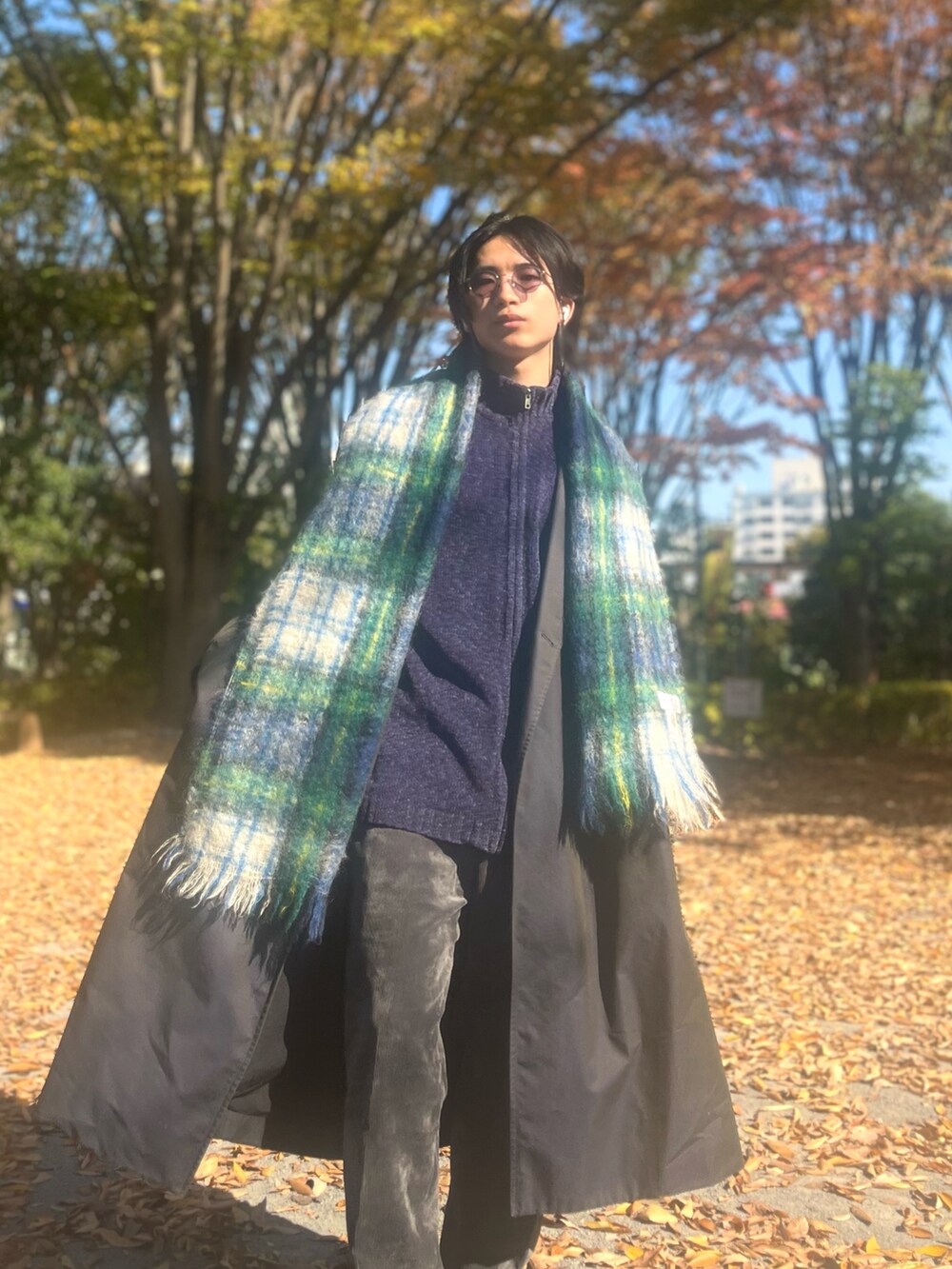 ブラック系のトレンチコート、ブラック系のスラックス、ブラック系のスニーカーを着用したメンズの冬コーディネートの2枚目の写真