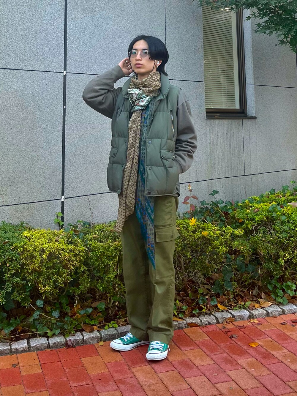 グリーン系のスニーカー、グリーン系のダウンベスト、グリーン系のカーゴパンツを着用したメンズの冬コーディネートの2枚目の写真