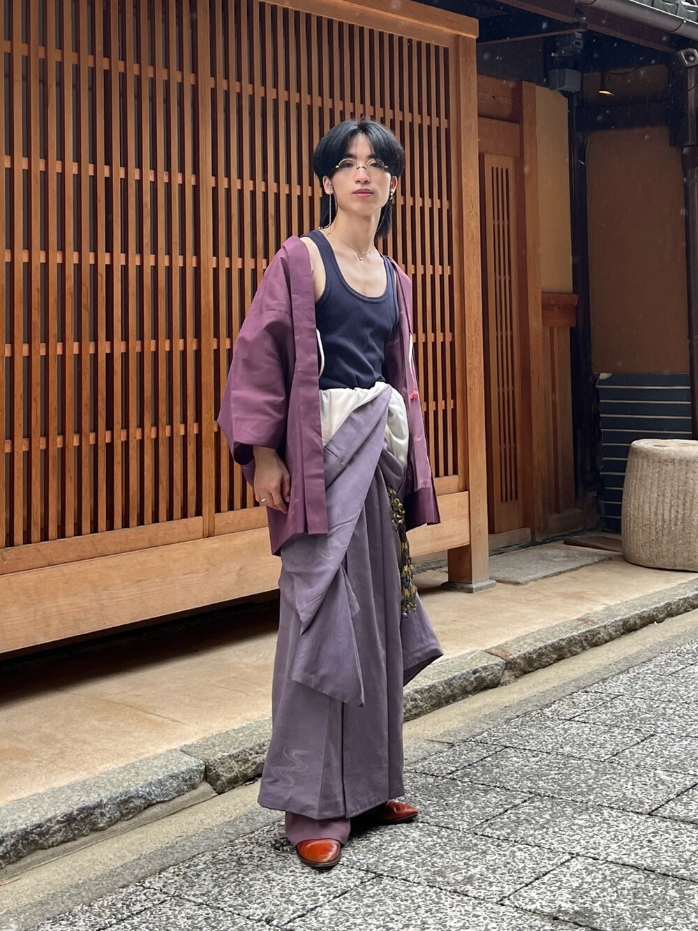 オレンジ系のブーツ、ブルー系のタンクトップ、ゴールド系のメガネを着用したメンズの秋コーディネートの2枚目の写真