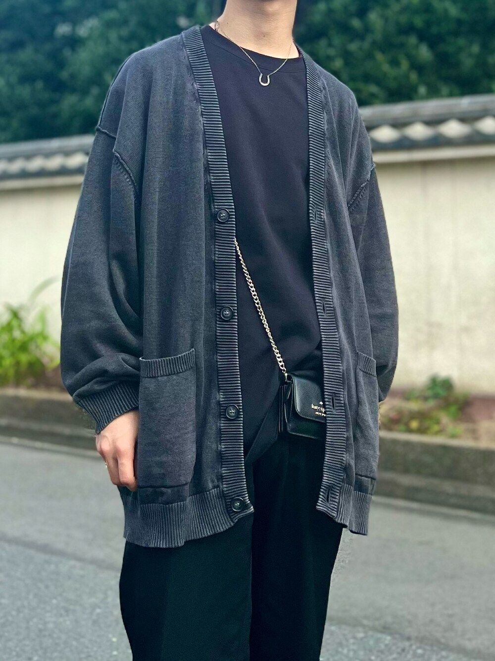 グレー系のカーディガン/ボレロ、ブラック系のスラックス、ブラック系のローファーを着用したメンズの秋コーディネートの3枚目の写真