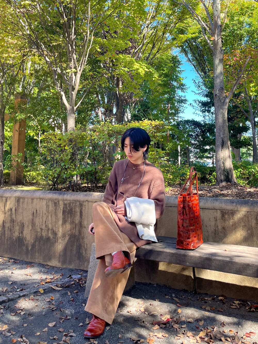 ブラウン系のニット/セーター、オレンジ系のトートバッグ、ブラウン系のその他パンツを着用したメンズの秋コーディネートの3枚目の写真