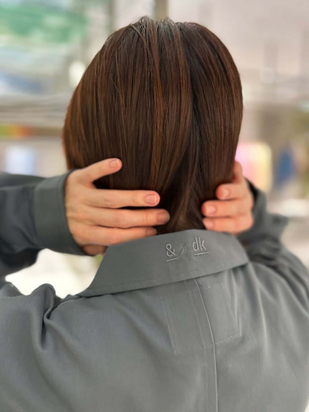 グレー系のシャツ/ブラウス、ホワイト系のニット/セーター、ブラック系のスラックスを着用したレディースの秋コーディネートの3枚目の写真