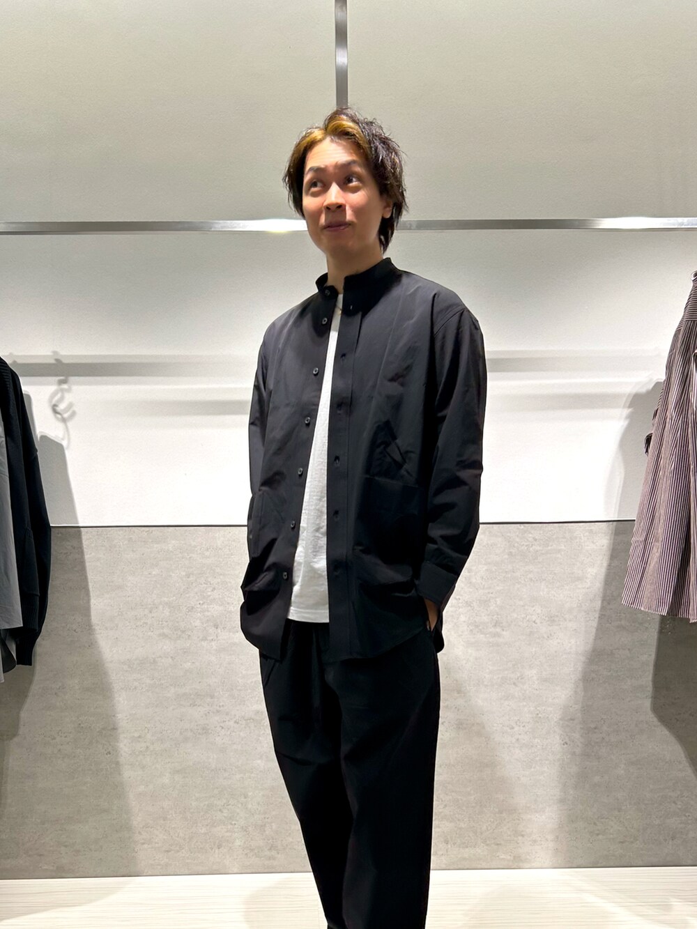 ホワイト系のスニーカー、ブラック系のスラックス、ブラック系のシャツ/ブラウスを着用したメンズの冬コーディネートの3枚目の写真