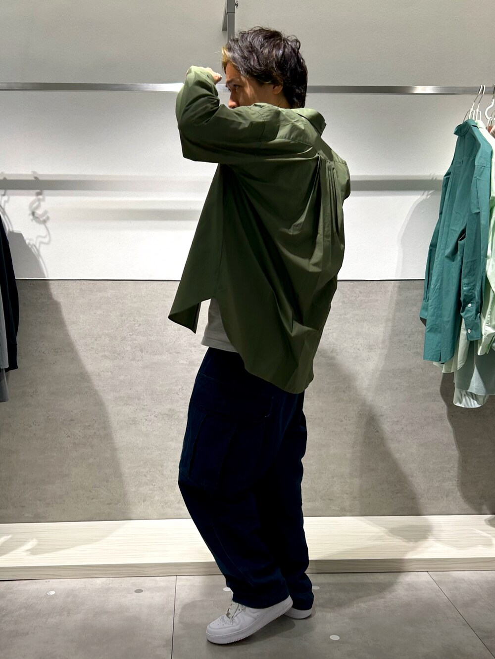グリーン系のシャツ/ブラウス、ブルー系のカーゴパンツ、ホワイト系のスニーカーを着用したメンズの秋コーディネートの2枚目の写真