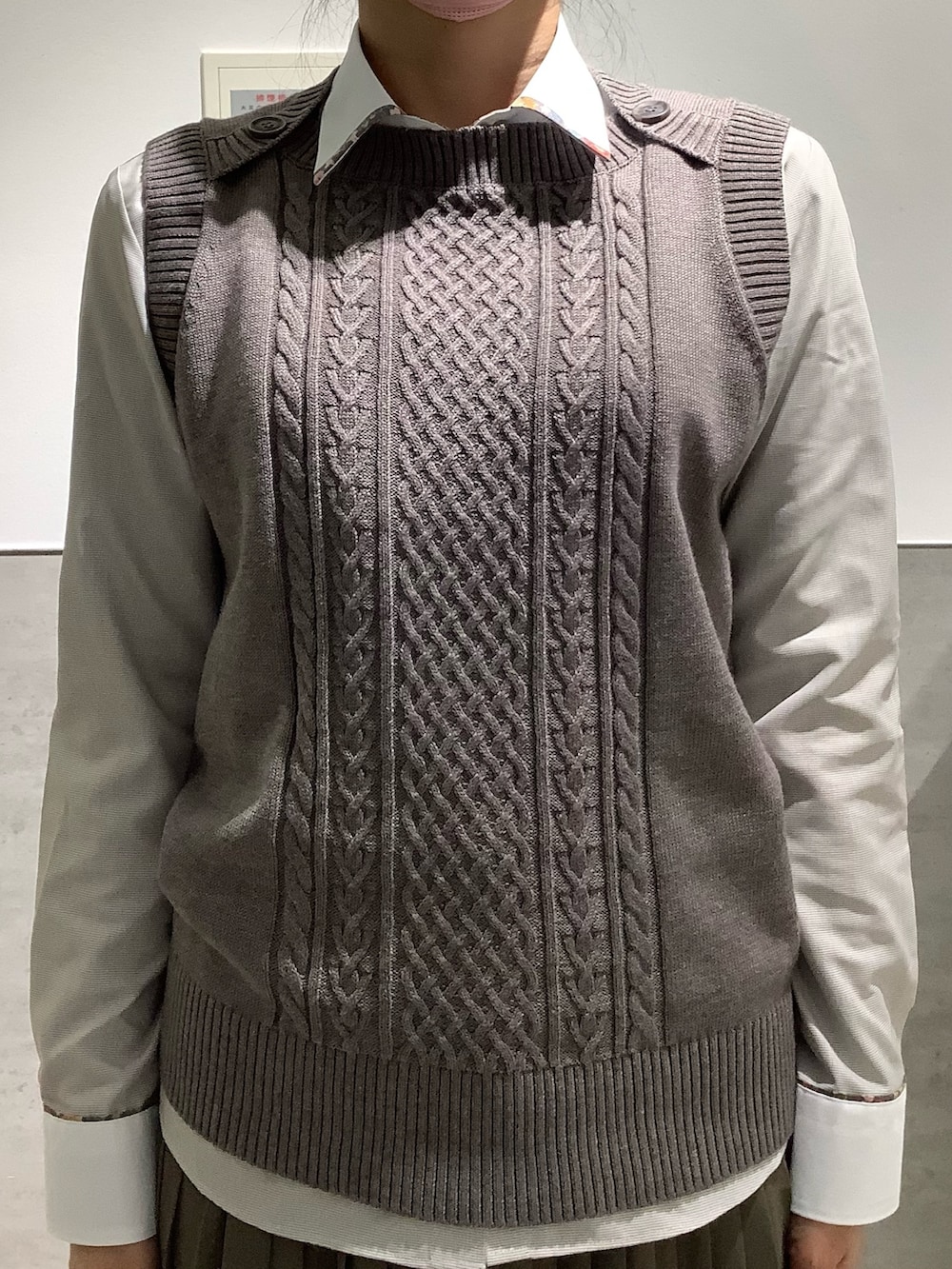 ブラウン系のベスト、ブラウン系のビジネスシャツを着用したレディースの秋コーディネートの2枚目の写真