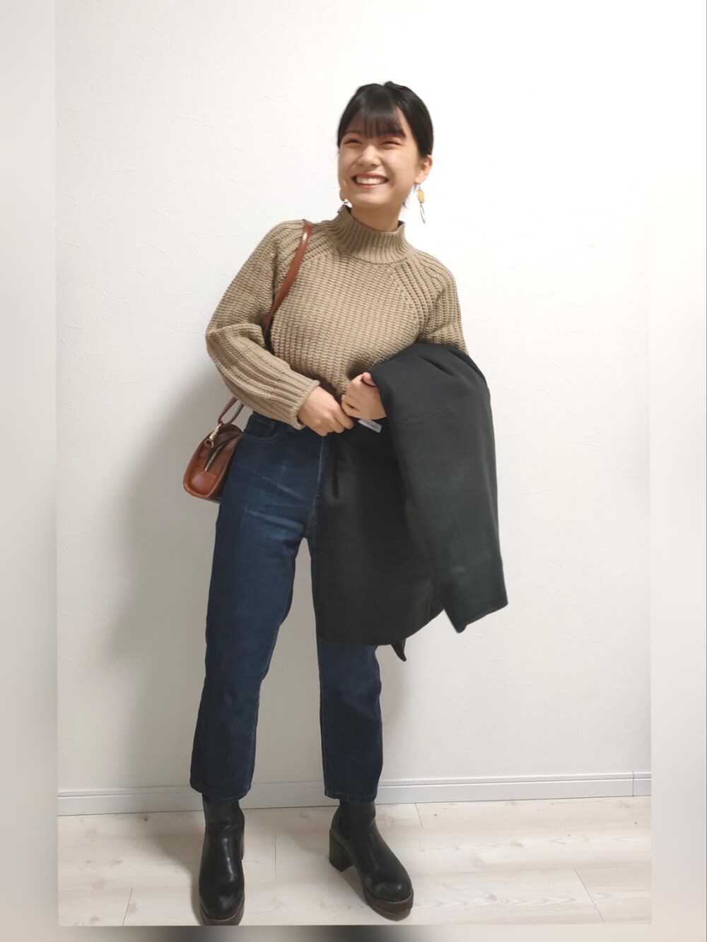 ブラウン系のショルダーバッグ、ブラック系のノーカラーコートを着用したレディースの冬コーディネートの2枚目の写真