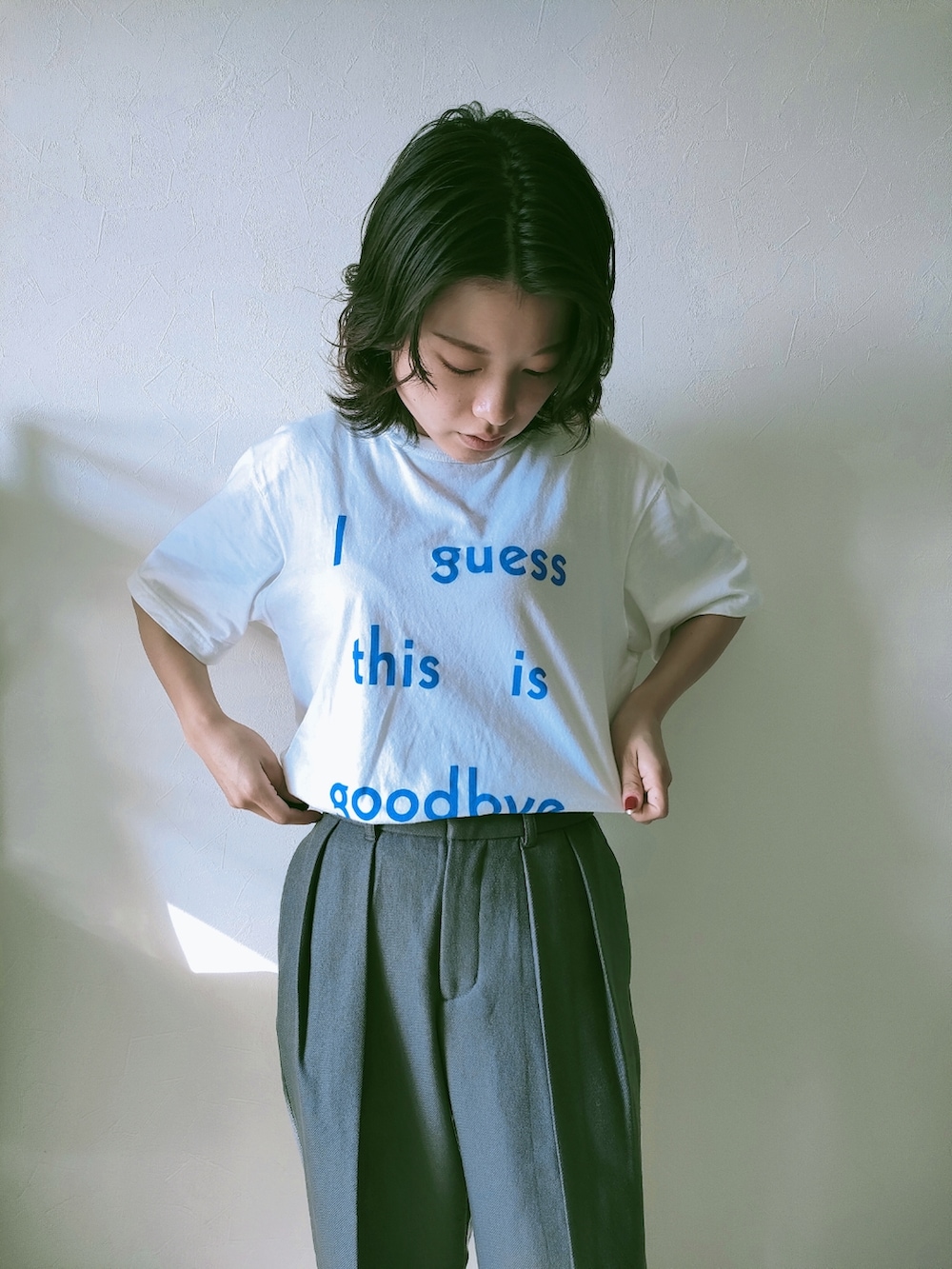 ホワイト系のTシャツ/カットソー、グレー系のスラックスを着用したレディースの春コーディネートの2枚目の写真