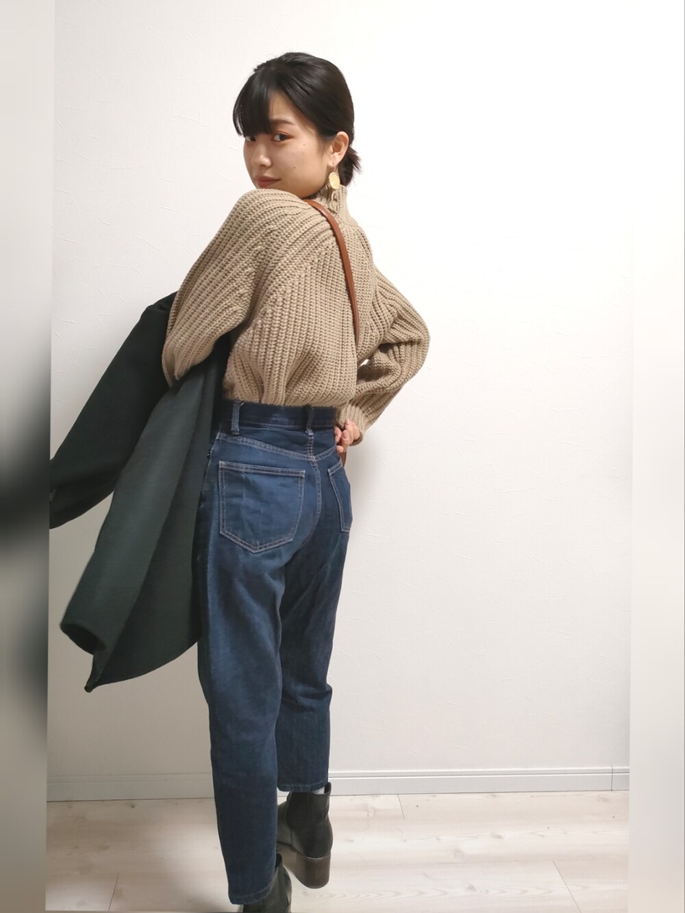 ブラウン系のショルダーバッグ、ブラック系のノーカラーコートを着用したレディースの冬コーディネートの3枚目の写真