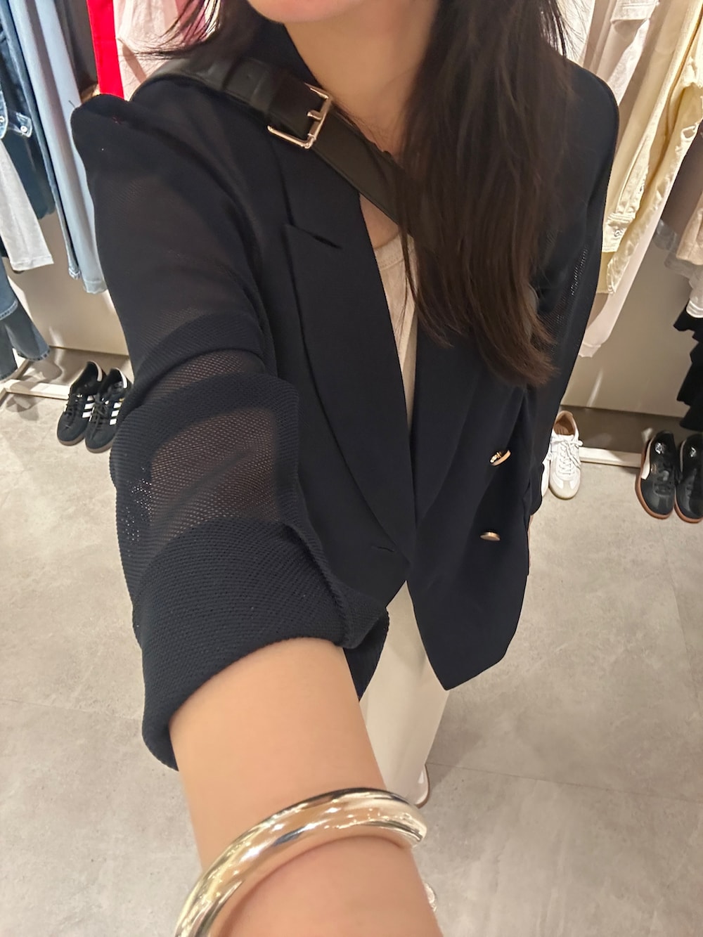 ホワイト系のスニーカー、ベージュ系のワンピース、ブラック系のショルダーバッグを着用したレディースの夏コーディネートの4枚目の写真