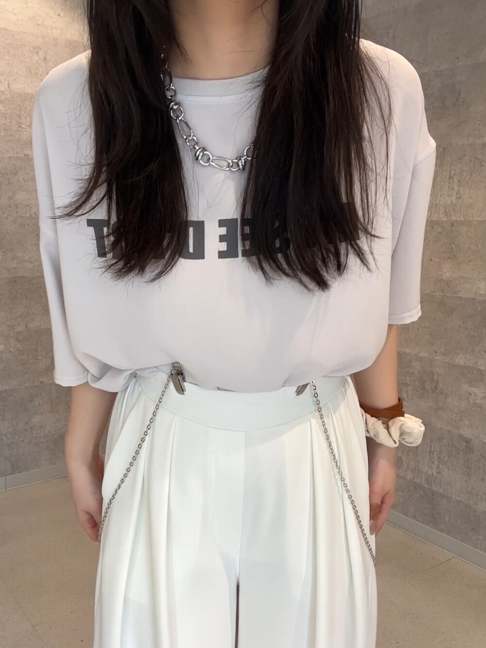 ホワイト系のスラックス、ベージュ系のテーラードジャケット、グレー系のシャツ/ブラウスを着用したレディースの夏コーディネートの3枚目の写真