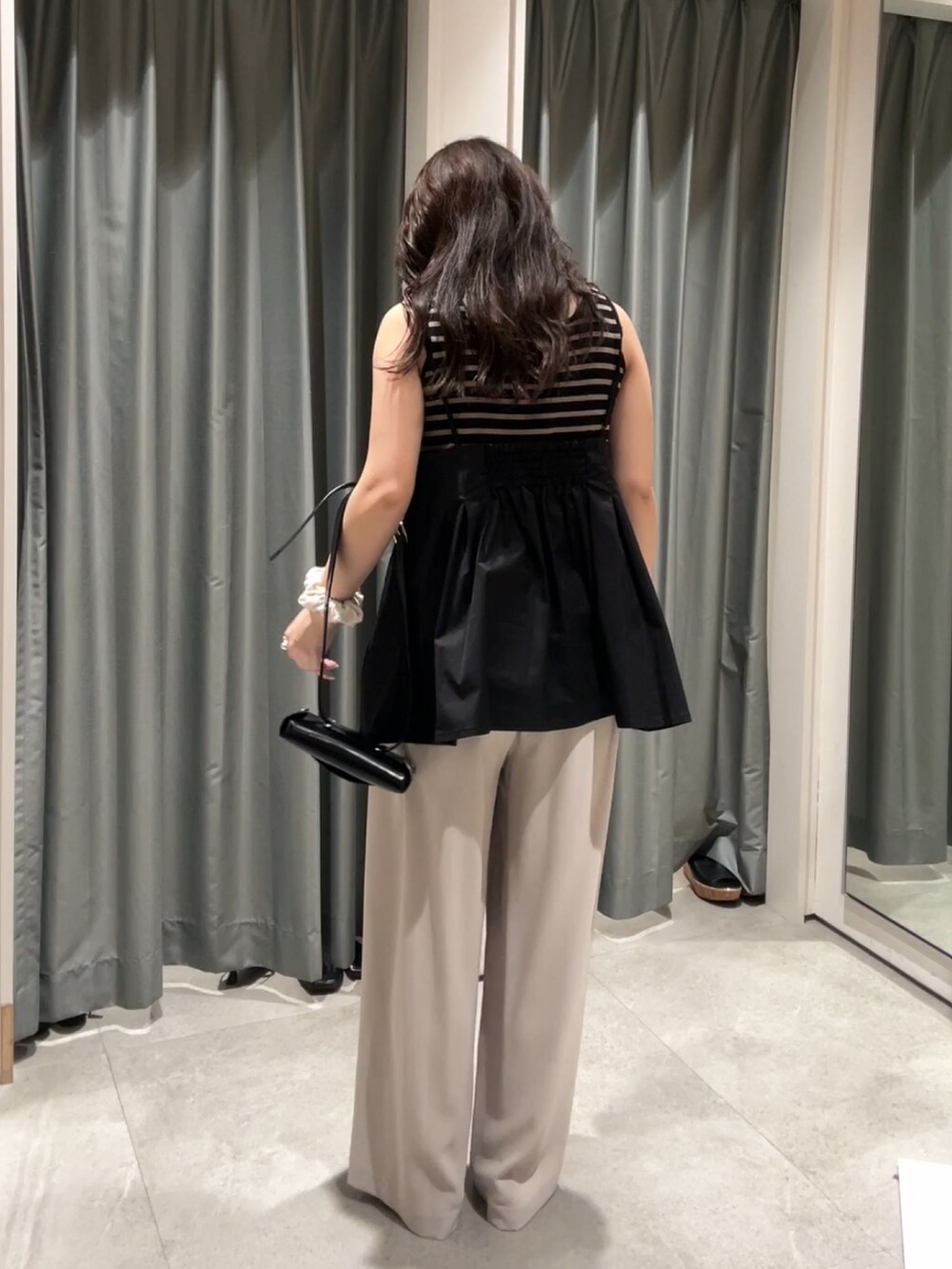 グレー系のスラックス、ブラック系のシャツ/ブラウス、ブラック系のショルダーバッグを着用したレディースの夏コーディネートの3枚目の写真