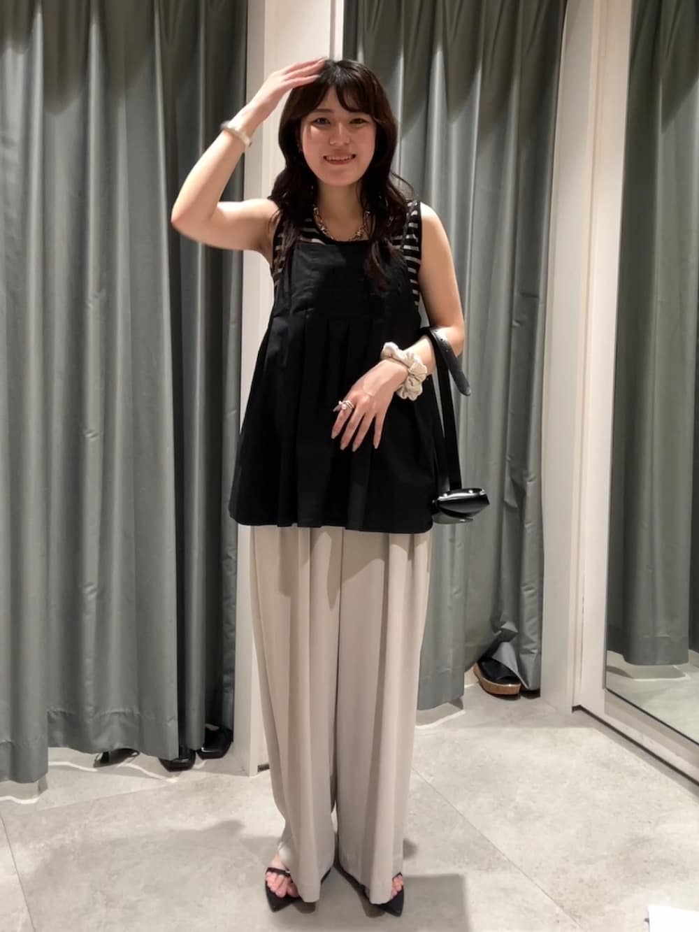 グレー系のスラックス、ブラック系のシャツ/ブラウス、ブラック系のショルダーバッグを着用したレディースの夏コーディネートの4枚目の写真