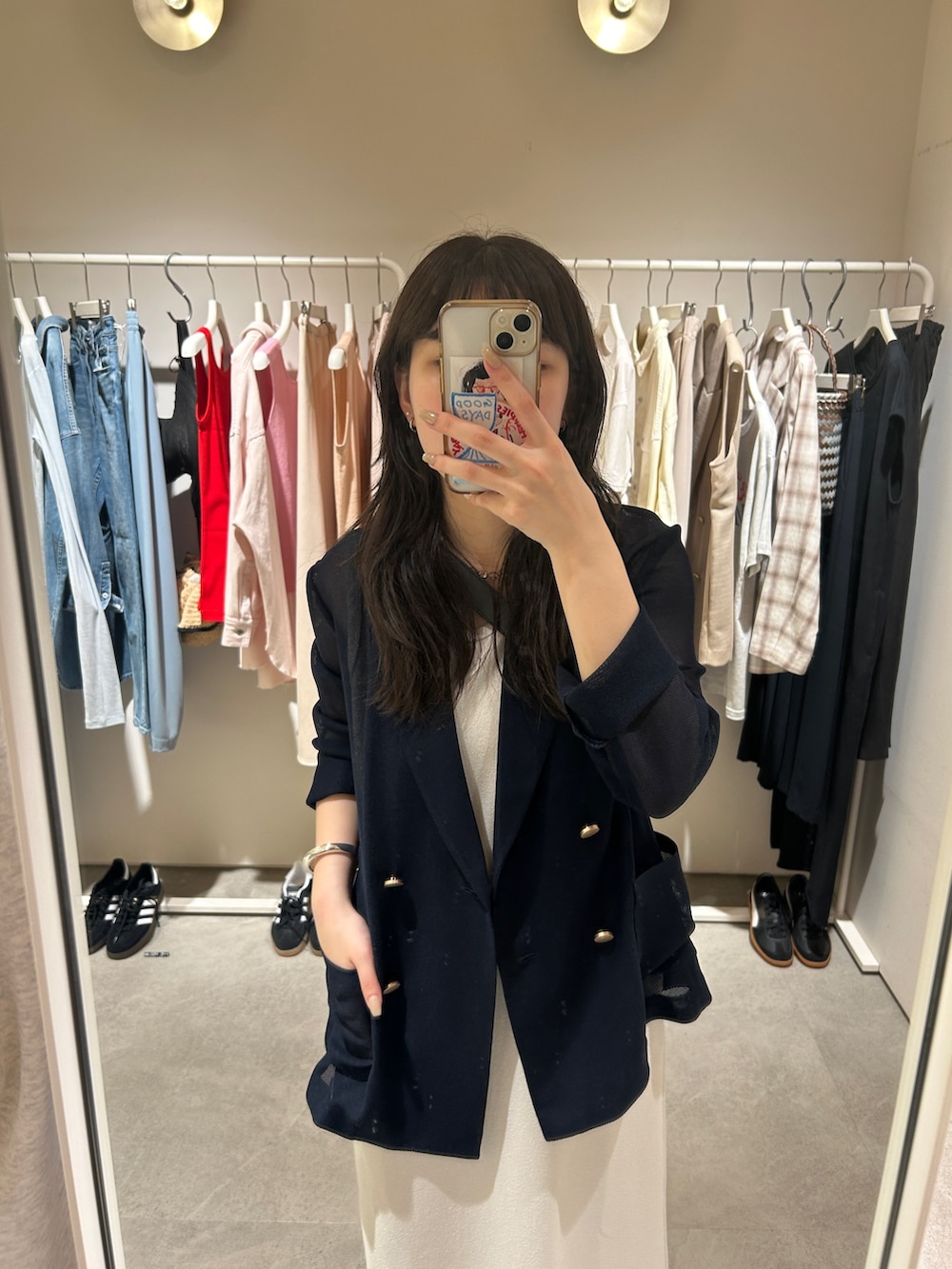 ホワイト系のスニーカー、ベージュ系のワンピース、ブラック系のショルダーバッグを着用したレディースの夏コーディネートの5枚目の写真