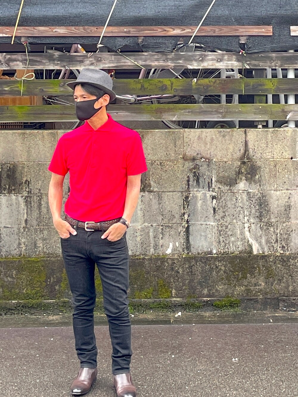 ピンク系のポロシャツ、ブラック系のデニムパンツ、ブラウン系のブーツを着用したメンズの夏コーディネートの2枚目の写真