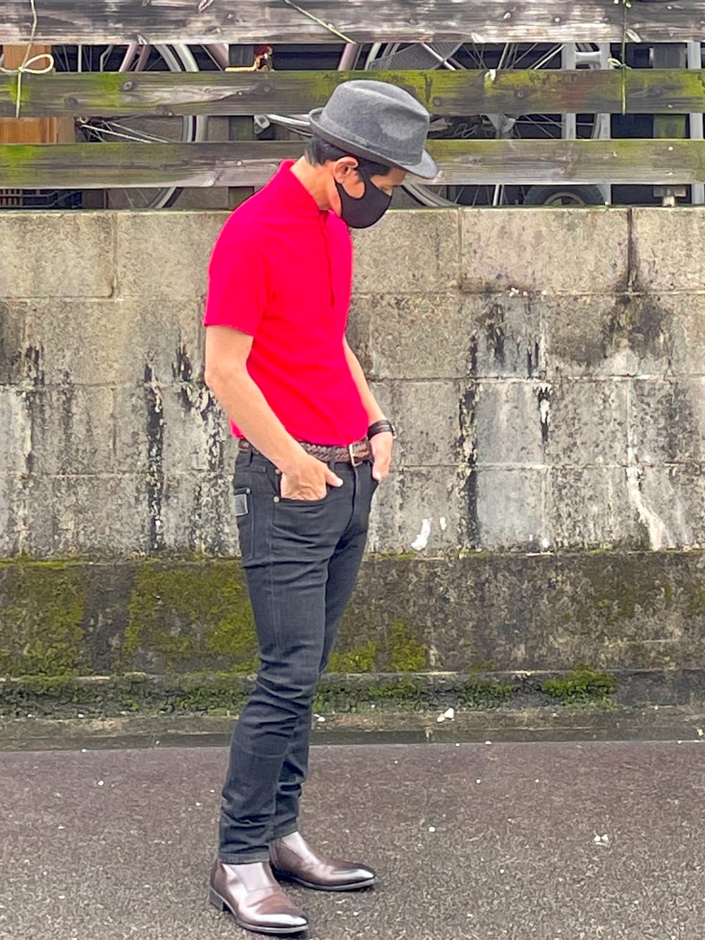 ピンク系のポロシャツ、ブラック系のデニムパンツ、ブラウン系のブーツを着用したメンズの夏コーディネートの4枚目の写真