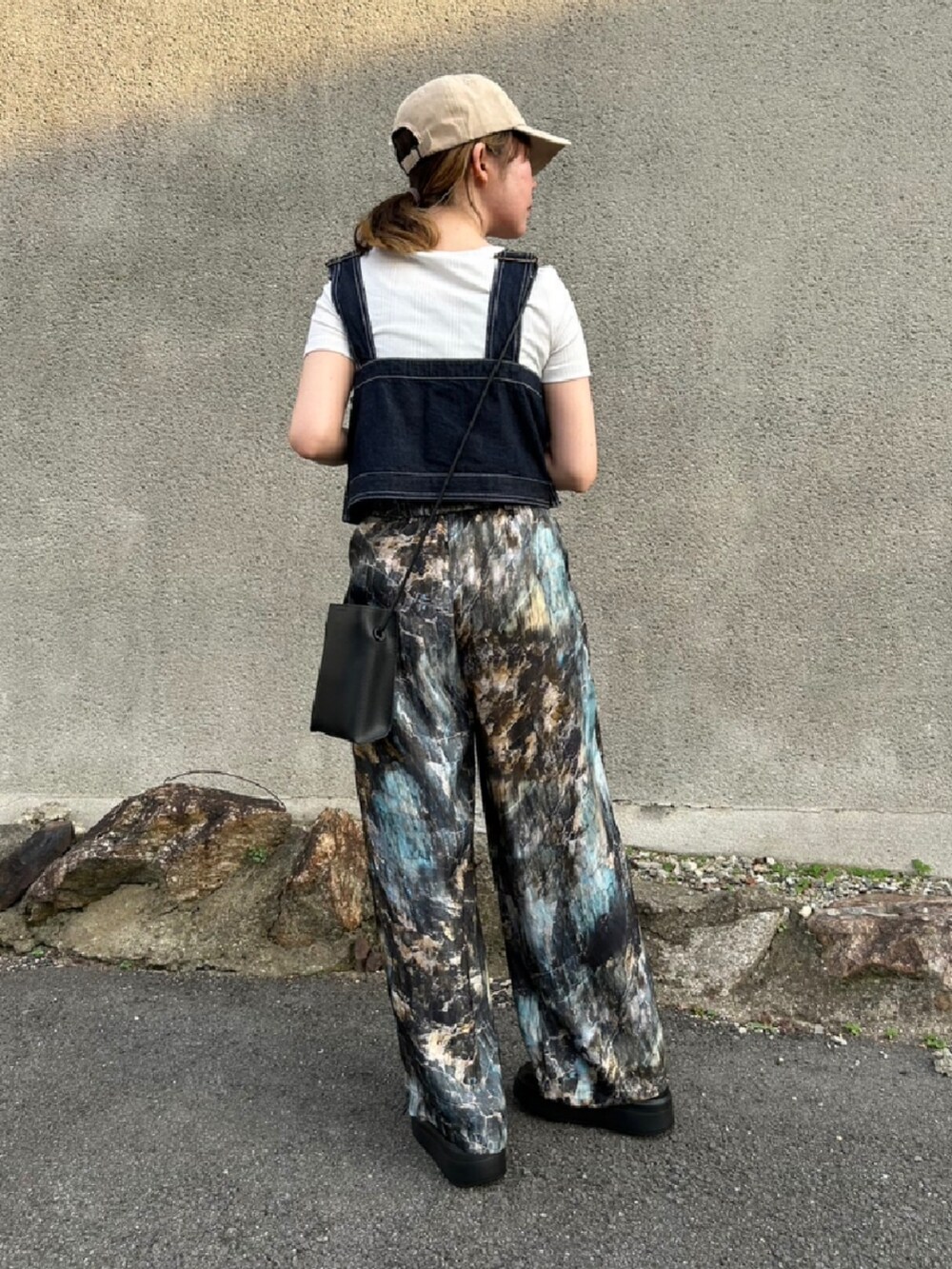 ブルー系のサロペット/オーバーオール、ブルー系のその他パンツ、ブラック系のスニーカーを着用したレディースの夏コーディネートの3枚目の写真