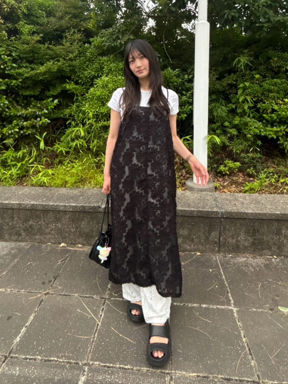 ブラック系のサンダル、ホワイト系のTシャツ/カットソーを着用したレディースの夏コーディネートの2枚目の写真
