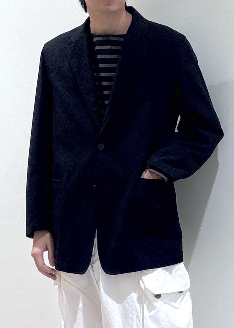 ホワイト系のカーゴパンツ、ブラウン系のTシャツ/カットソー、ブラック系のテーラードジャケットを着用したメンズの春コーディネートの3枚目の写真