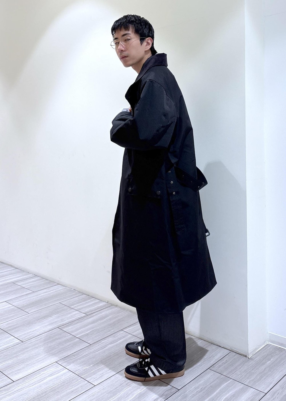 ブラック系のトレンチコートを着用したメンズの秋コーディネートの2枚目の写真