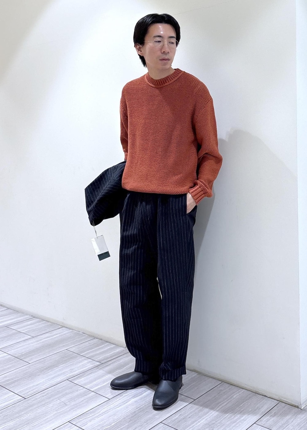 ブルー系のスラックス、ブルー系のノーカラージャケット、オレンジ系のニット/セーターを着用したメンズの冬コーディネートの5枚目の写真