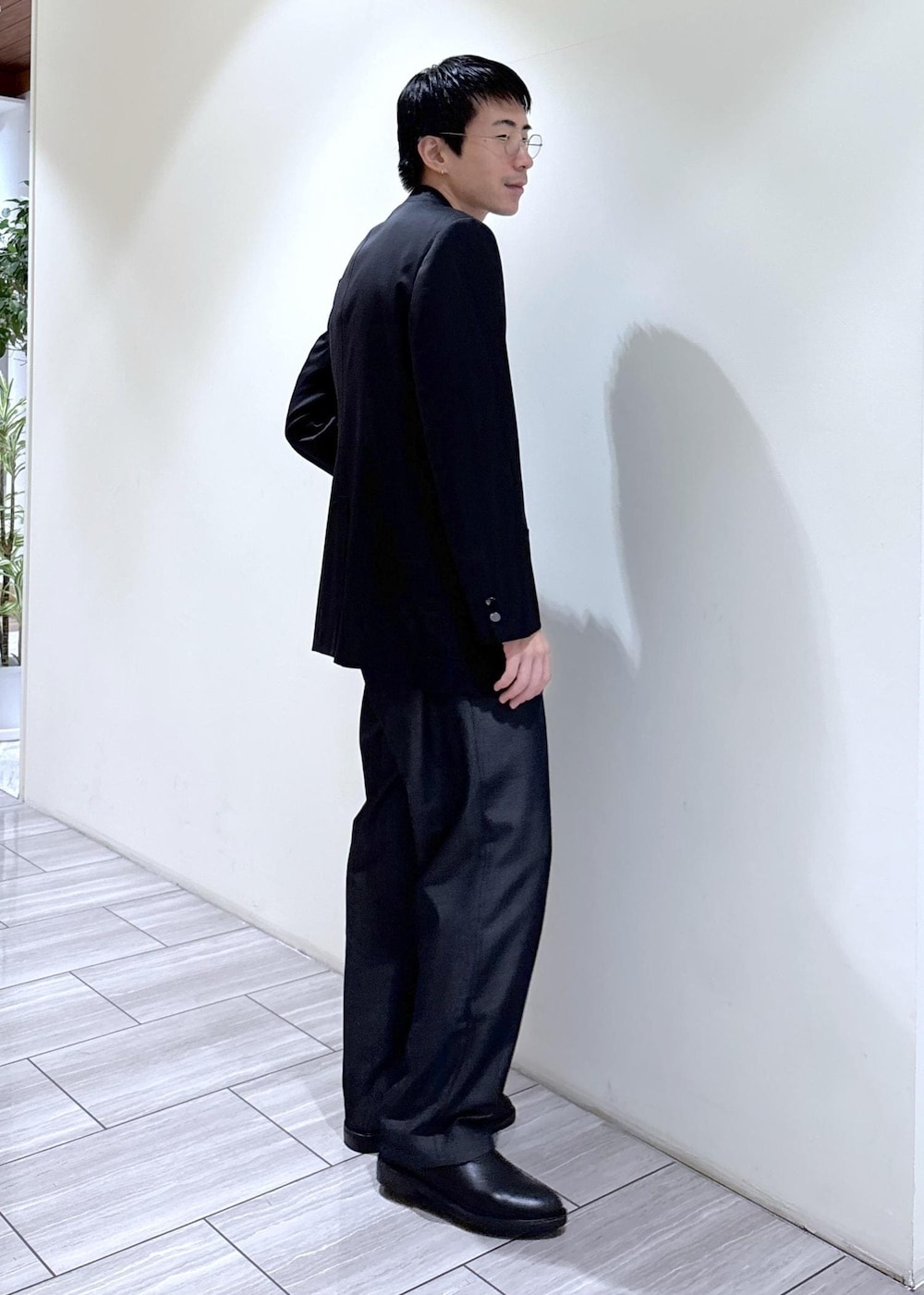 ブラック系のデニムパンツ、グリーン系のニット/セーター、ブラック系のテーラードジャケットを着用したメンズの秋コーディネートの3枚目の写真
