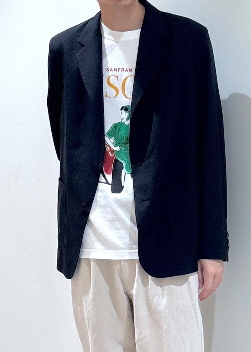 ブラック系のテーラードジャケット、ホワイト系のスラックス、ホワイト系のTシャツ/カットソーを着用したメンズの夏コーディネートの2枚目の写真