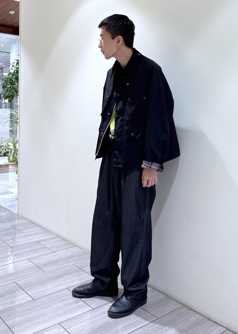 ブラック系のデニムパンツ、イエロー系のTシャツ/カットソー、ブラック系のブルゾンを着用したメンズの秋コーディネートの2枚目の写真