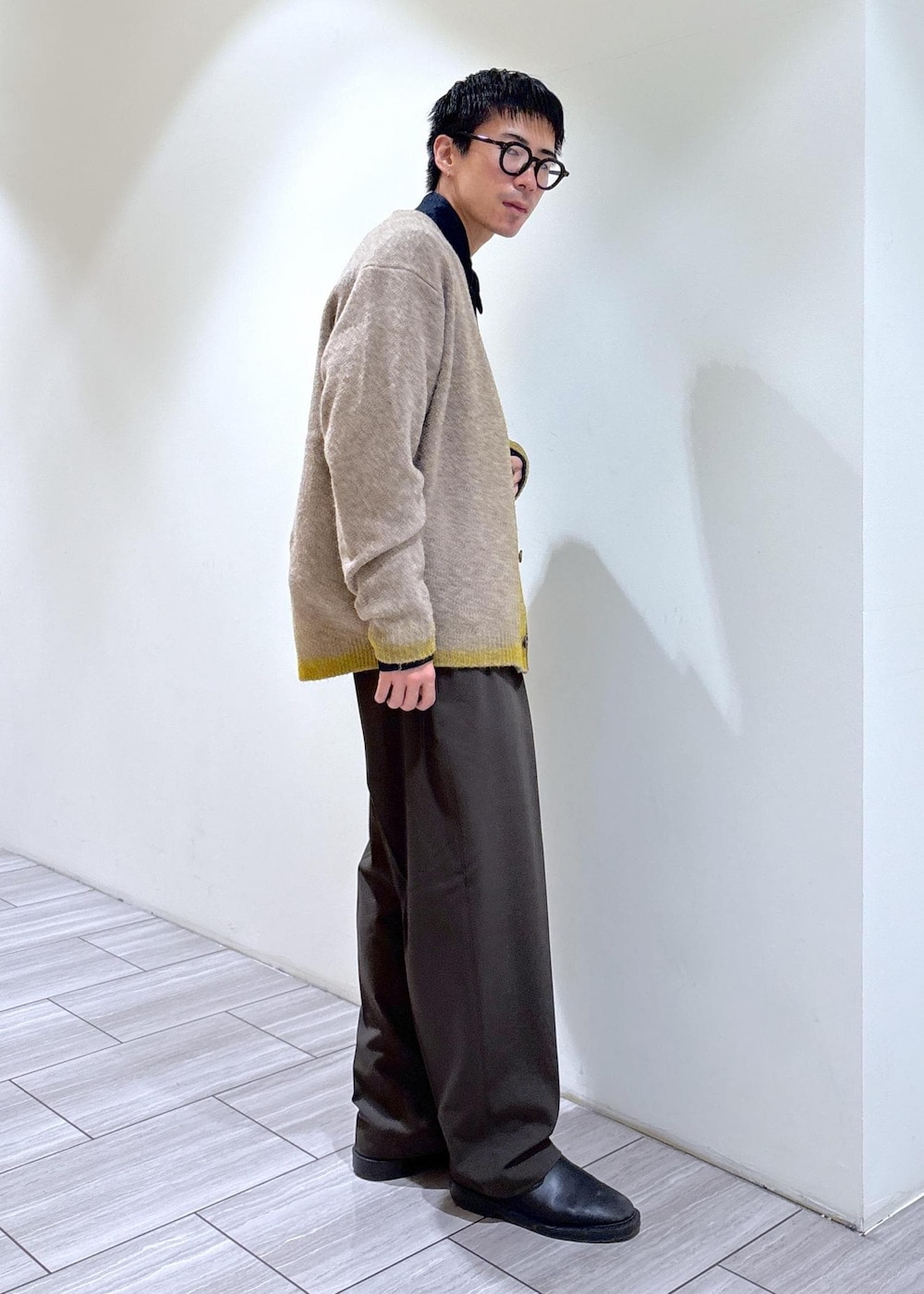 イエロー系のカーディガン/ボレロ、ブルー系のデニムジャケット、グレー系のニット/セーターを着用したメンズの秋コーディネートの2枚目の写真